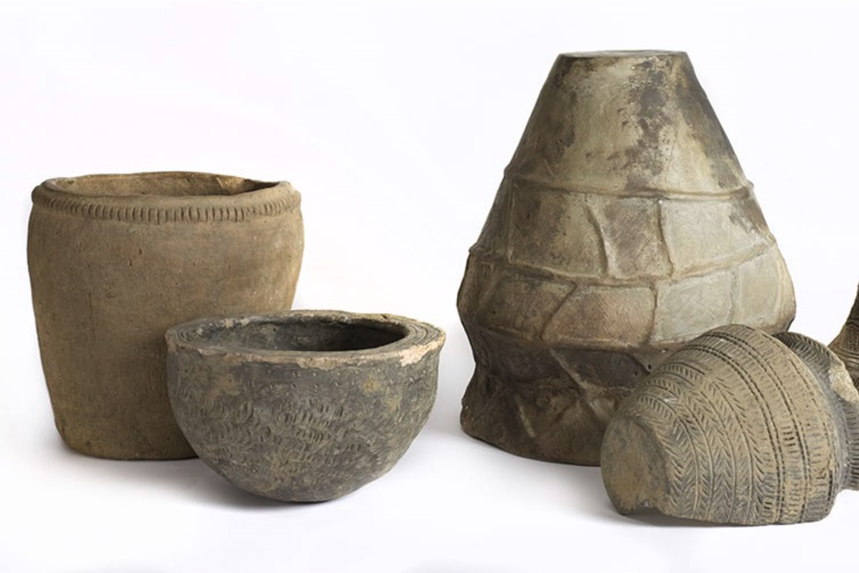 Image of 4 different shaped old, clay pots against white background.