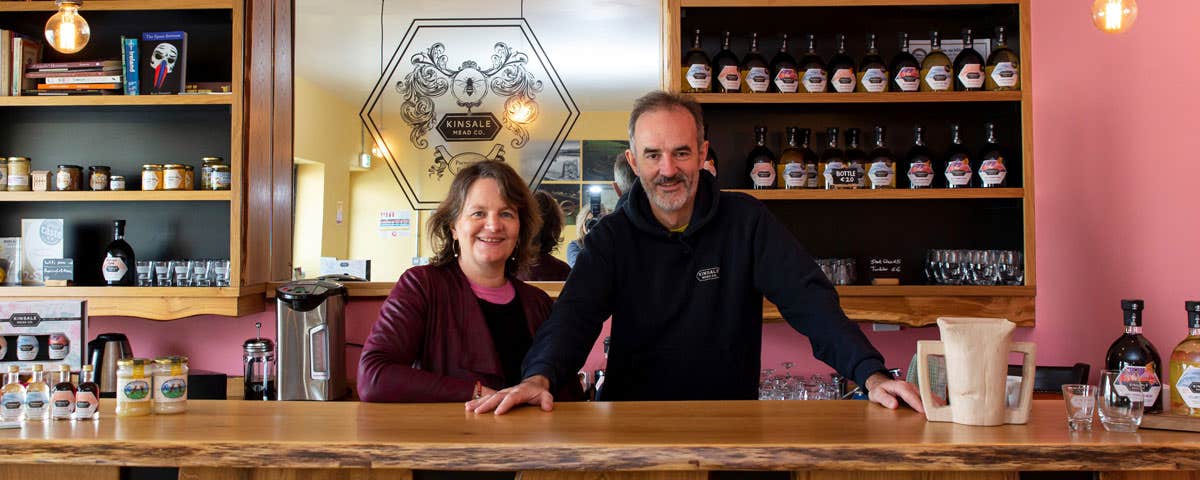 Two people standing behind a counter in Kinsale Mead Company