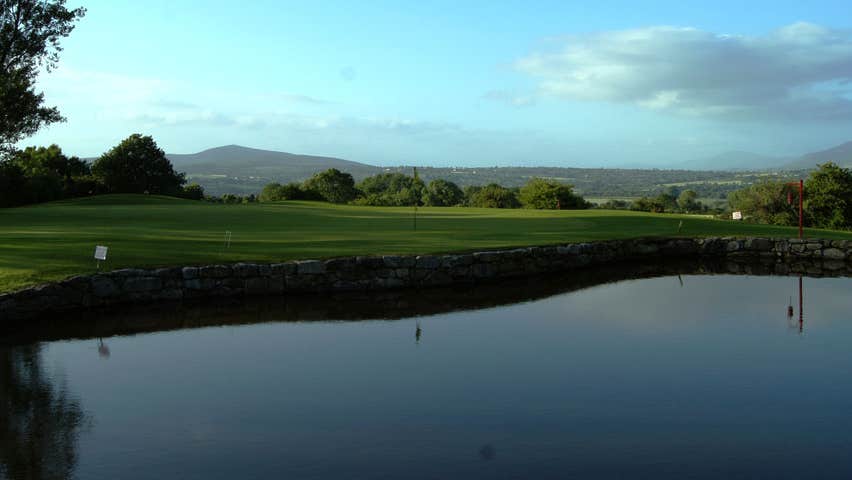 A golf course beside a pond