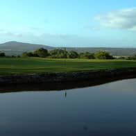 A golf course beside a pond