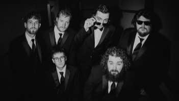 Ole 60, black and white photo of 6 men in dark suits and ties.
