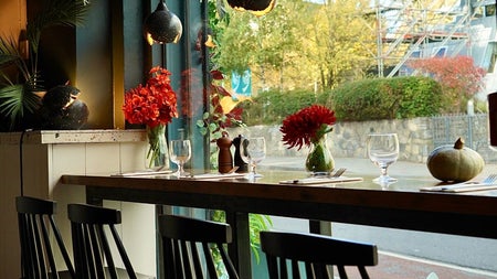 A counter lined with place settings and flowers in vases