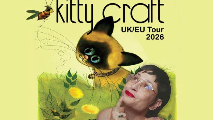 A woman smiling looking up at a cartoon image of a cat