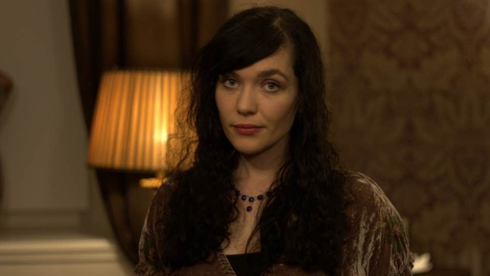 A woman sat beside a dimly lit orange lamp.