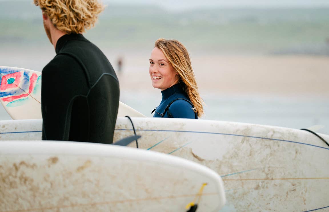 Surfers carrying surfboards at Lahinch, County Clare