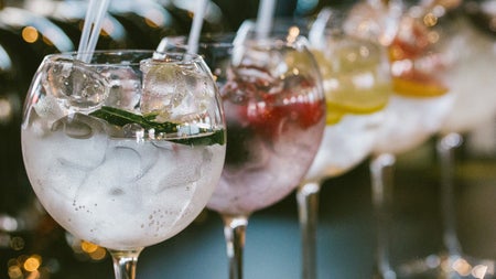 A row of gin cocktails sitting on the bar