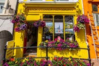 Colourful exterior of a photographic gallery with window boxes and displays of flowers
