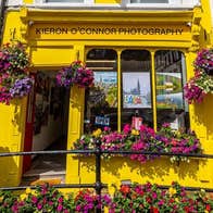 Colourful exterior of a photographic gallery with window boxes and displays of flowers