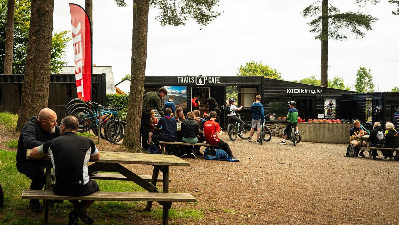 People sitting on picnic benches outside a café