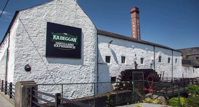 The exterior of the Kilbeggan Distillery Experience building with the old chimney in the background