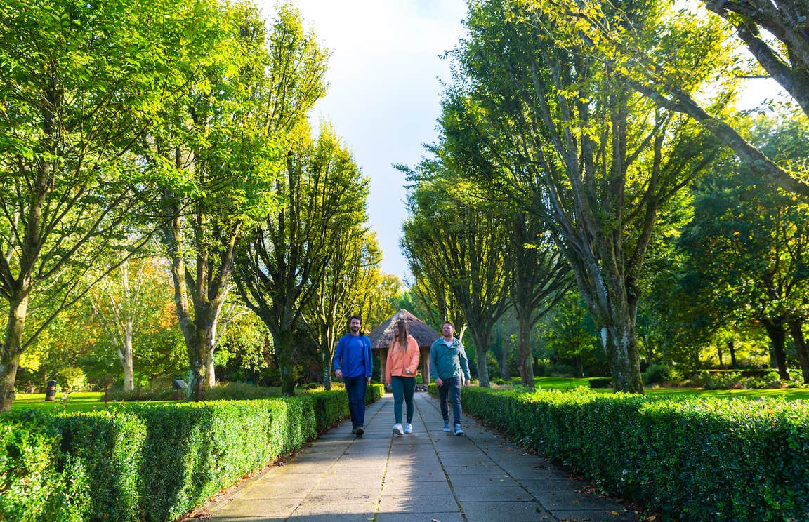 Three people walking in Adare Town Park in County Limerick.