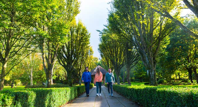 Three people walking in Adare Town Park in County Limerick.