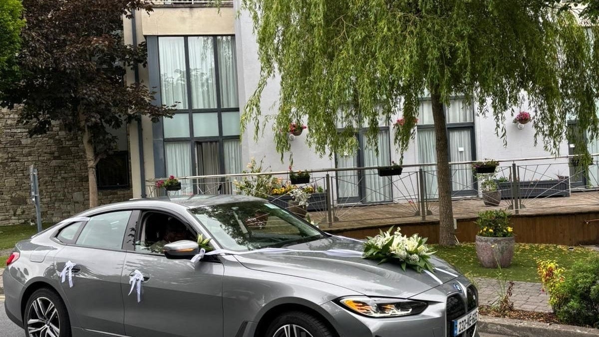 Decorated car parked on a street outside a building with an open window