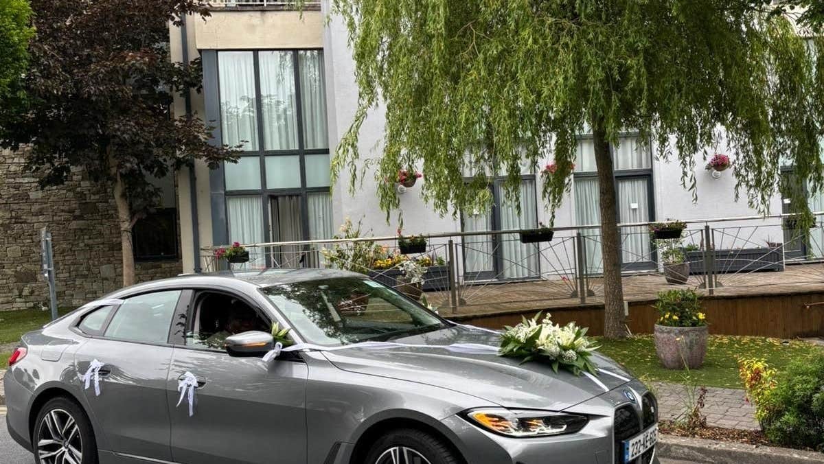 Decorated car parked on a street outside a building with an open window