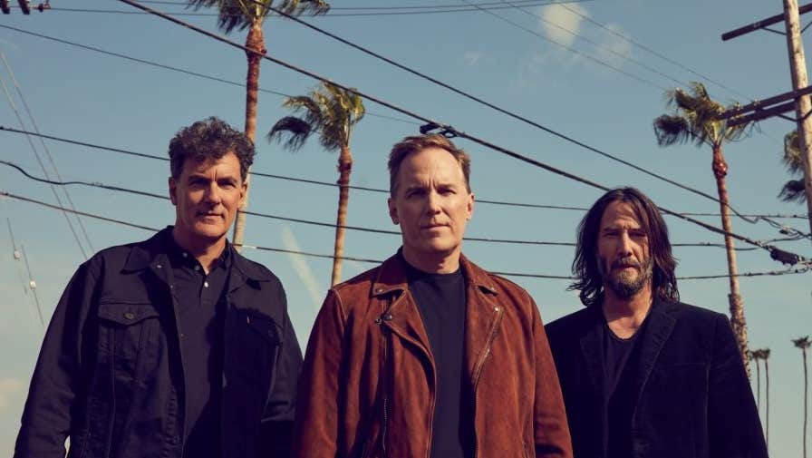 American alternative rock outfit Dogstar, 3 men outdoors with tall palm trees in the background.