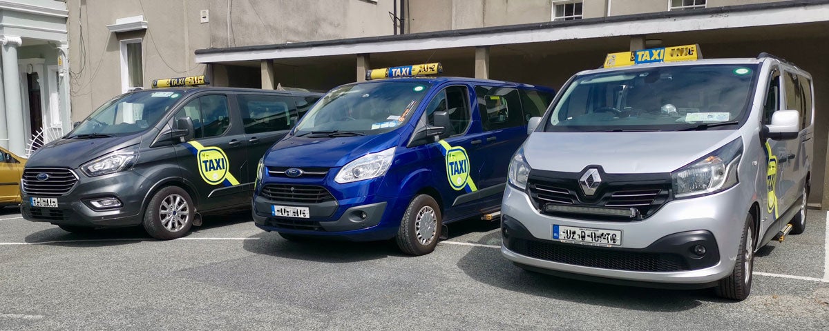 Three minivans side by side with taxi signs