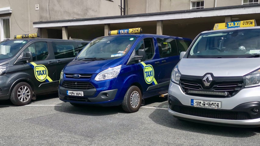 Three minivans side by side with taxi signs