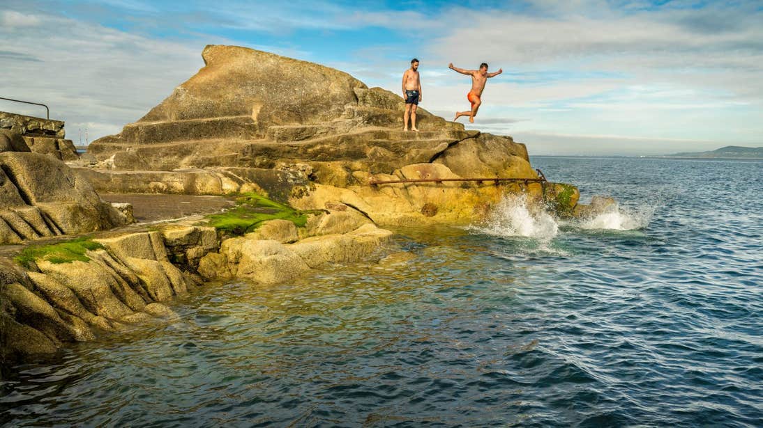 People jumping off rocks at The Forty Foot in Sandycove, Dublin