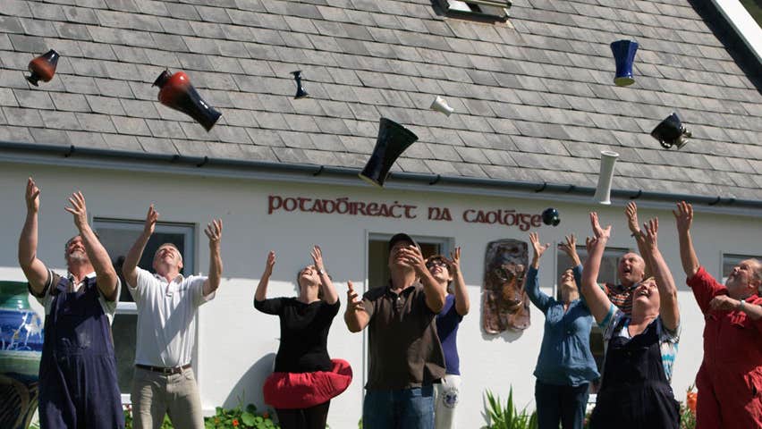 People throwing pottery in the air outside Louis Mulcahy Pottery