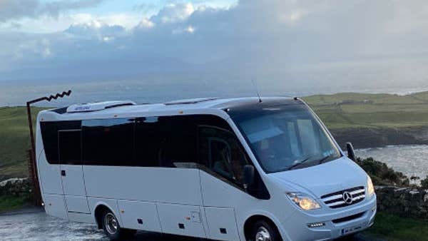 Donegal Coach Hire white bus at a sea view stop