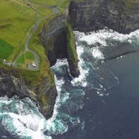 Helicopter view of the Cliffs of Moher with a glimpse of O Briens Tower
