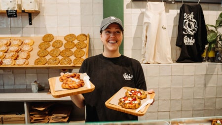 A lady standing behind the counter in a bakery