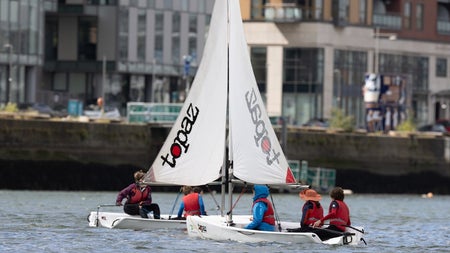 Two dinghies on a river in a city