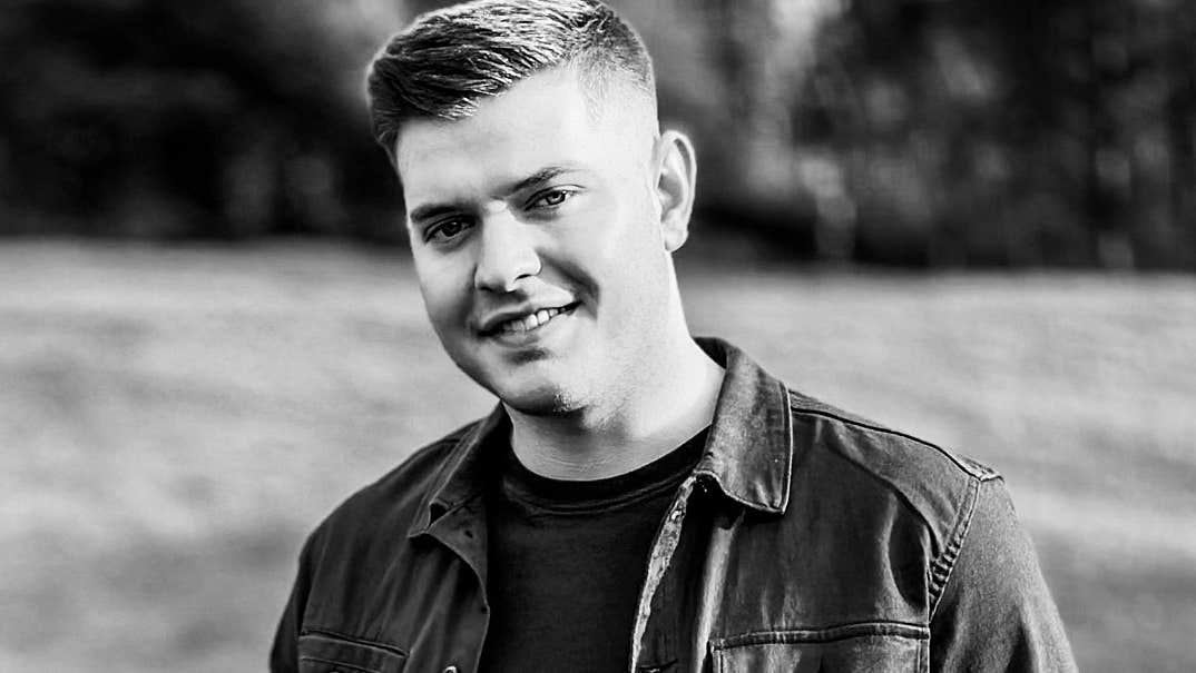 Jack Keogh Dance in the Gleneagle Ballroom. Black and white photo of man slightly smiling, outdoors wearing a jacket.