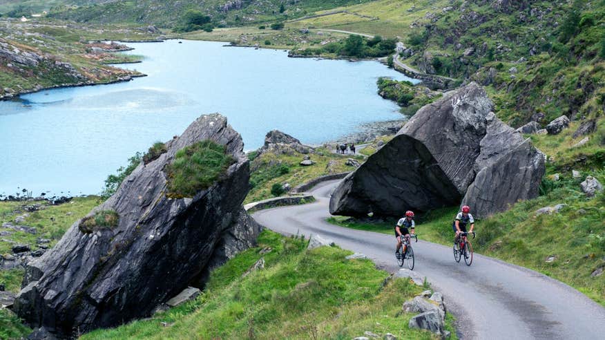 Two people cycling up a hill on the Ring of Kerry in County Kerry