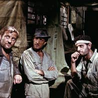 Five grimy men are having a discussion.