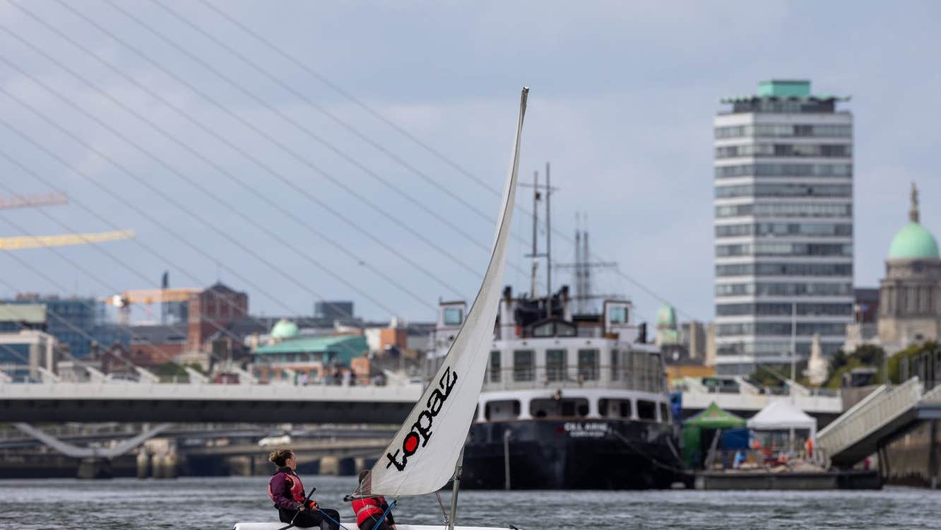 A dingy on the water with a city view in the background