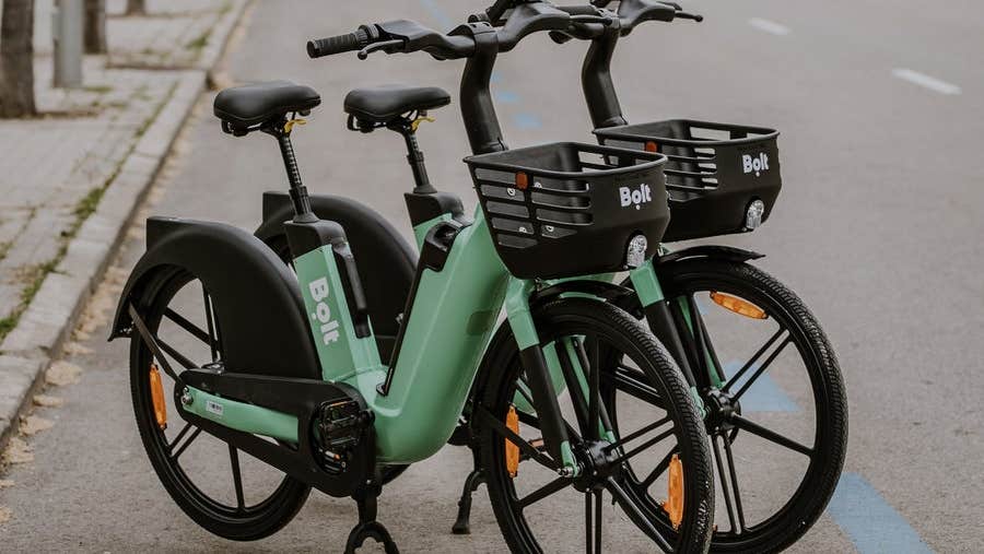 Two green coloured Bolt e-bikes parked on a street