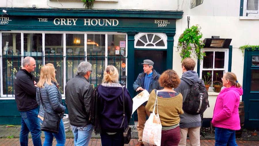 Historic Stroll of Kinsale Walking Tour on the street outside The Greyhound Pub with a group of seven people.
