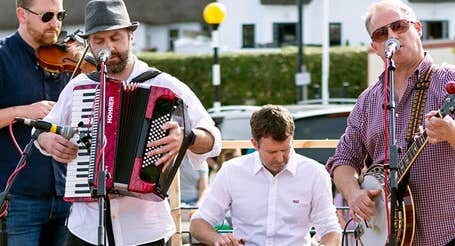 Dunmore East Bluegrass Festival, 4 musicians performing outdoors in a town.