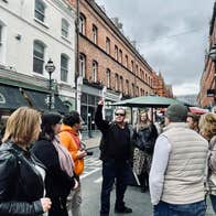 A tour group and guide on a busy city street