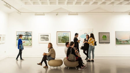 People sitting and people standing in a spacious gallery