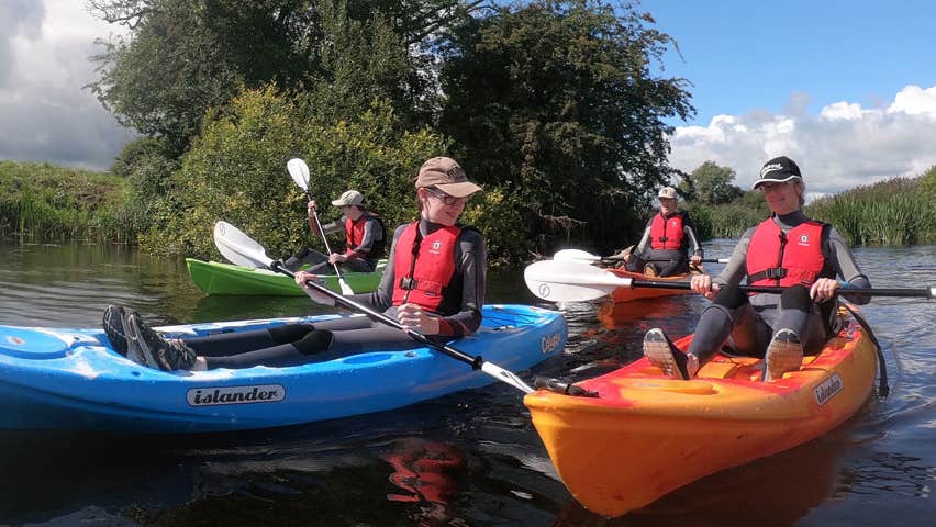 A group of people enjoying a kayak on the river on a sunny day