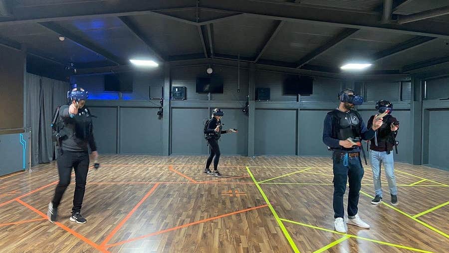 People standing in a room with VR headsets playing a virtual reality game