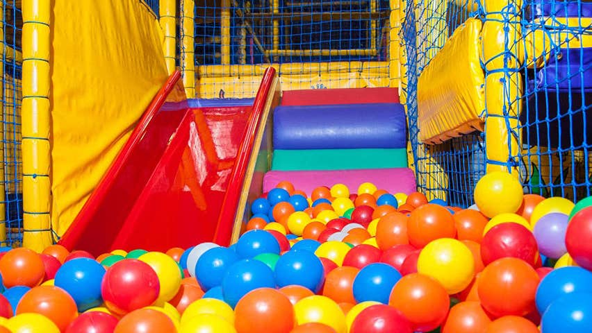 A slide leading down to a ball pool in a kids indoor play area
