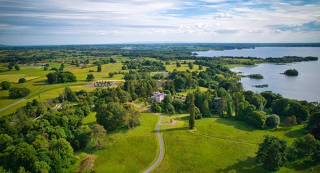 An aerial view of a large country estate with a period house in the distance