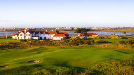 A view of a large clubhouse overlooking a golf course