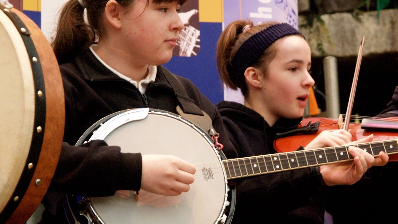 A girl playing the banjo and a girl playing the fiddle at Des Carty Music School