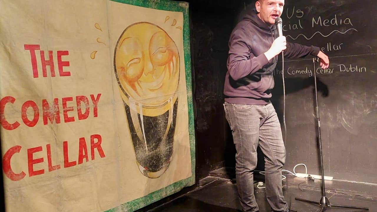 A comedian standing on a stage with a microphone