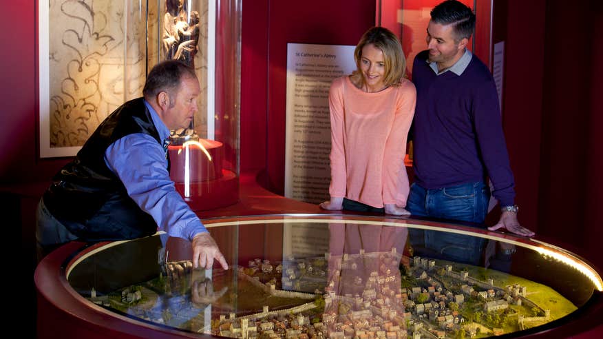 A tour guide leading two people through the exhibits at Waterford Treasures in County Waterford.