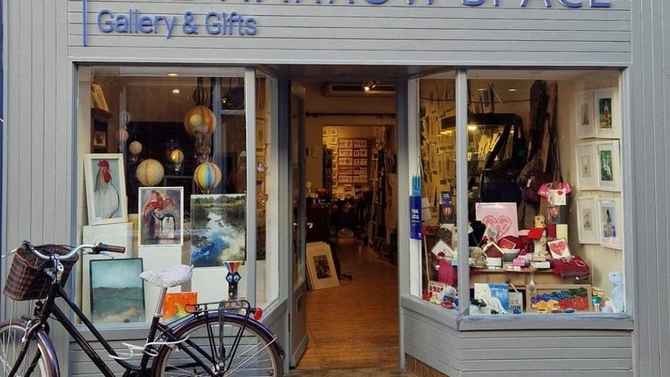 Exterior of a gallery with an eclectic mix of items on display in the windows