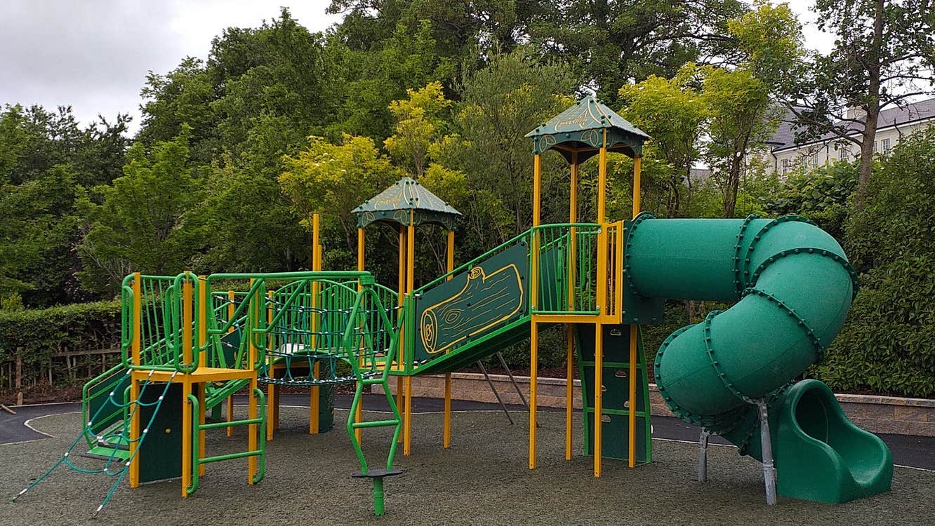 Green and yellow multi unit play area for young kids in a playground