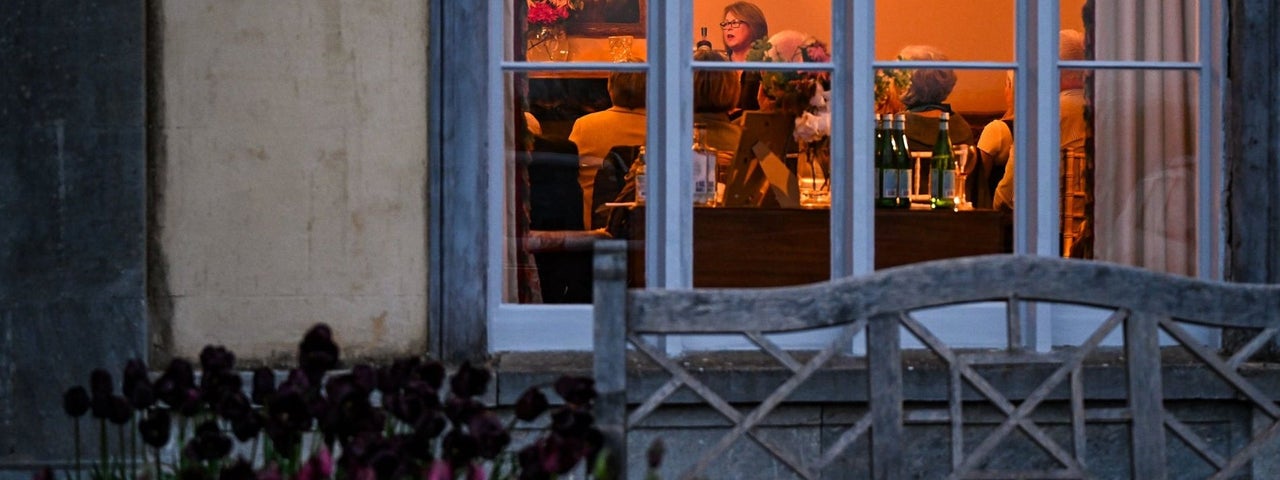 View through a window to a group of people at a story telling evening