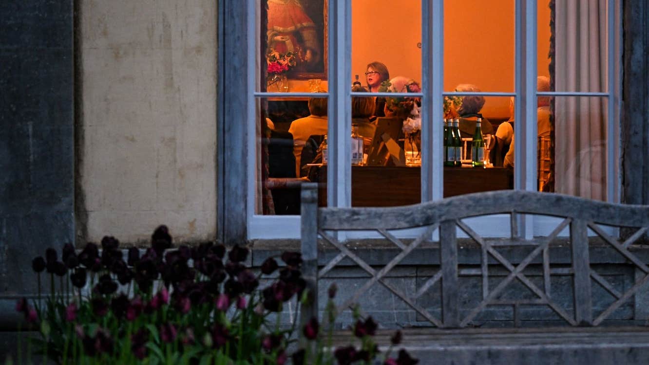 View through a window to a group of people at a story telling evening
