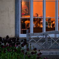 View through a window to a group of people at a story telling evening