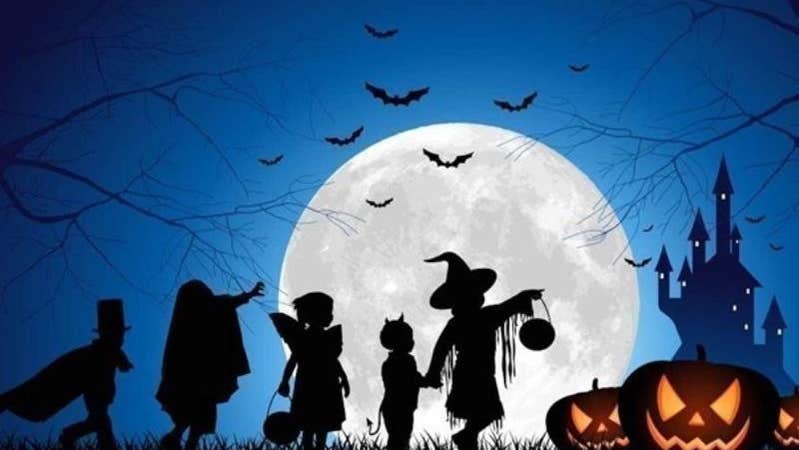 Children trick or treating in the moonlight on Halloween.